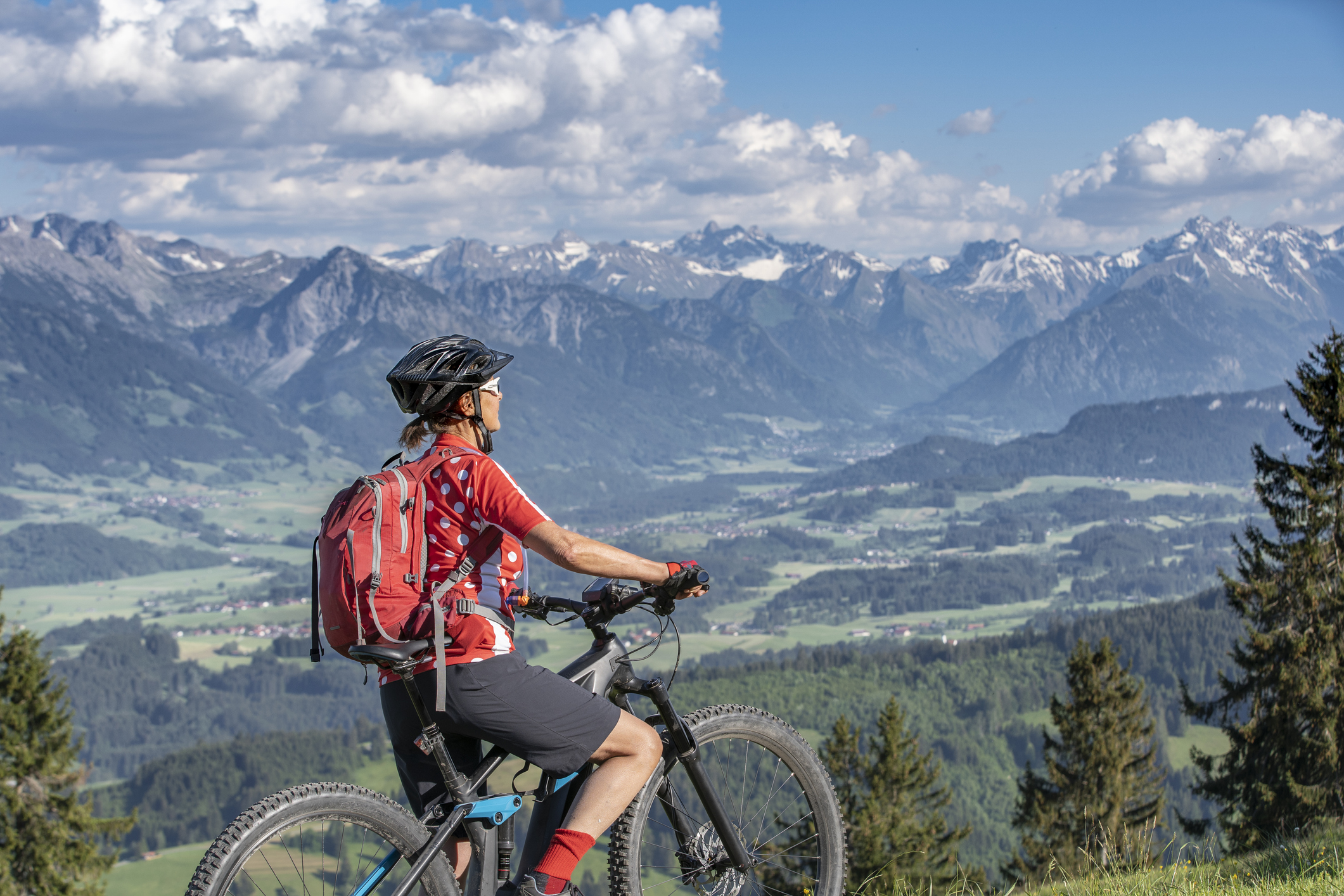 Biker looking out at mountains in background.