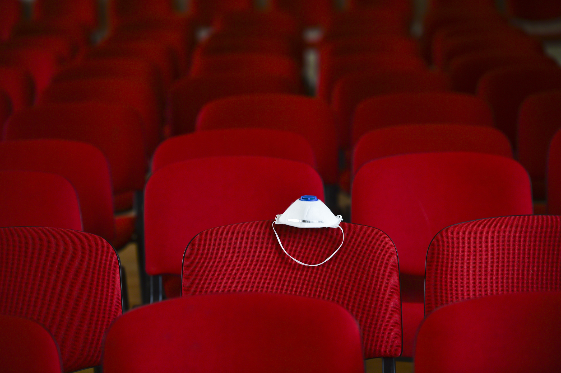 Empty theater with a facemask on a seat.