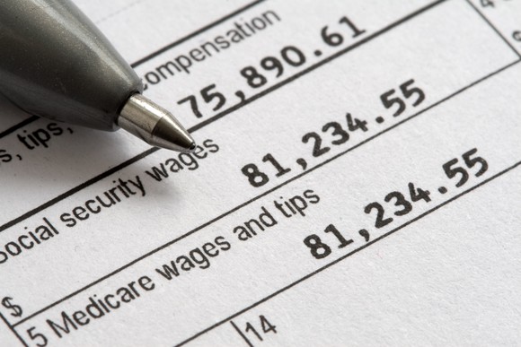 The tip of a pen pointing toward Social Security taxable wages on a W-2 tax form. 
