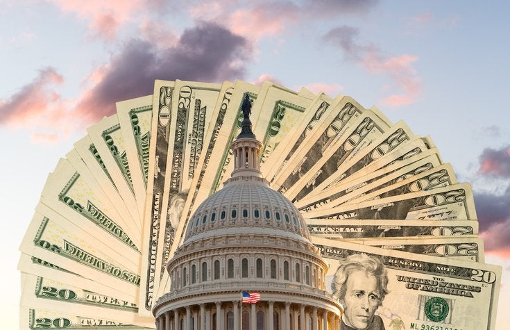 Top of the capital building with a fan of twenty dollar bills spread out behind it.