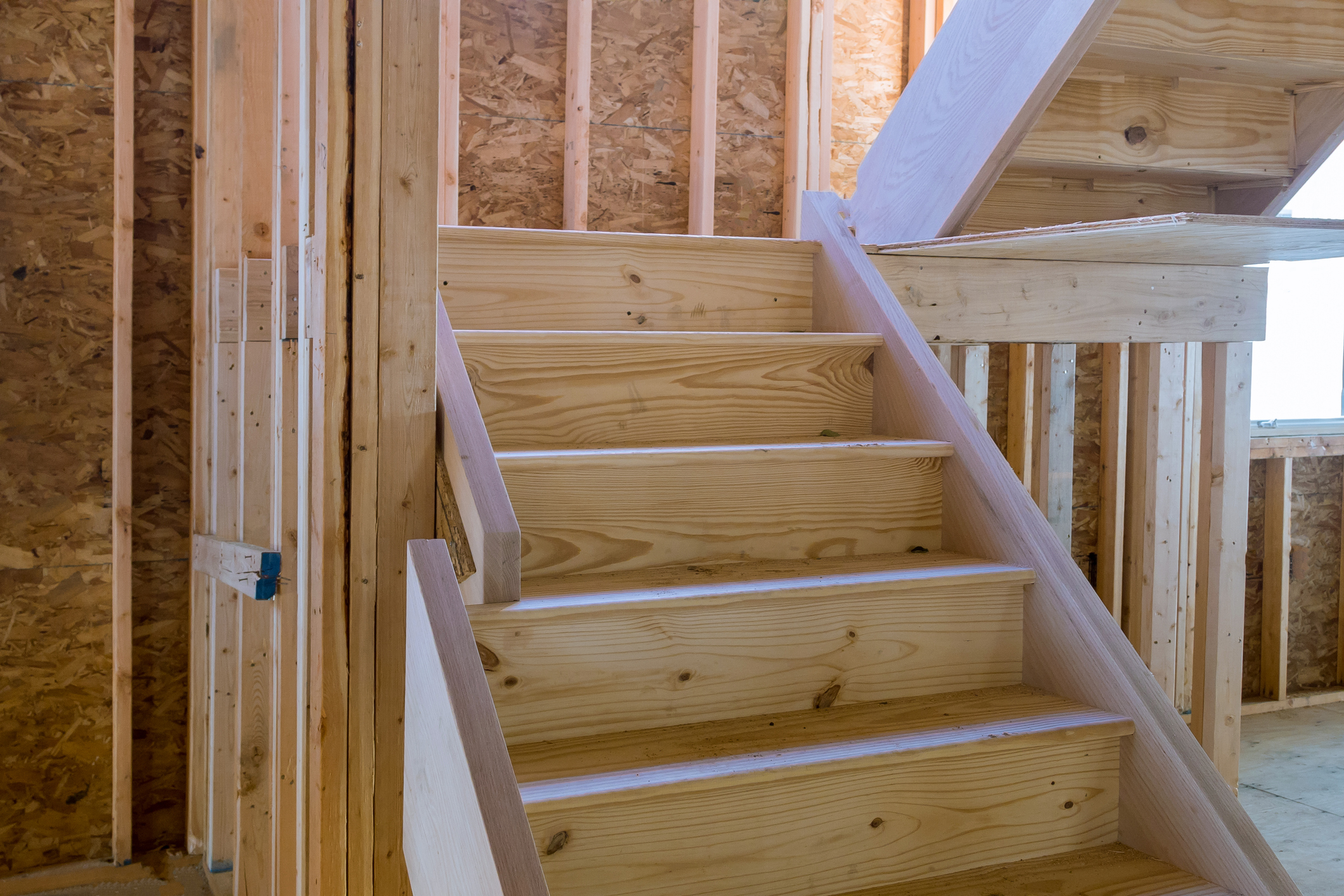 A view from inside a home under construction: stairway and landing.