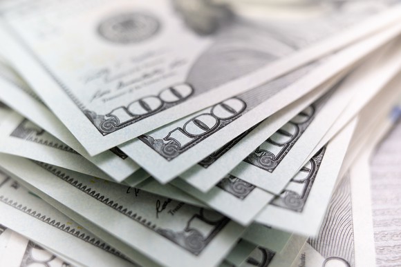 A messy stack of one hundred dollar bills. 