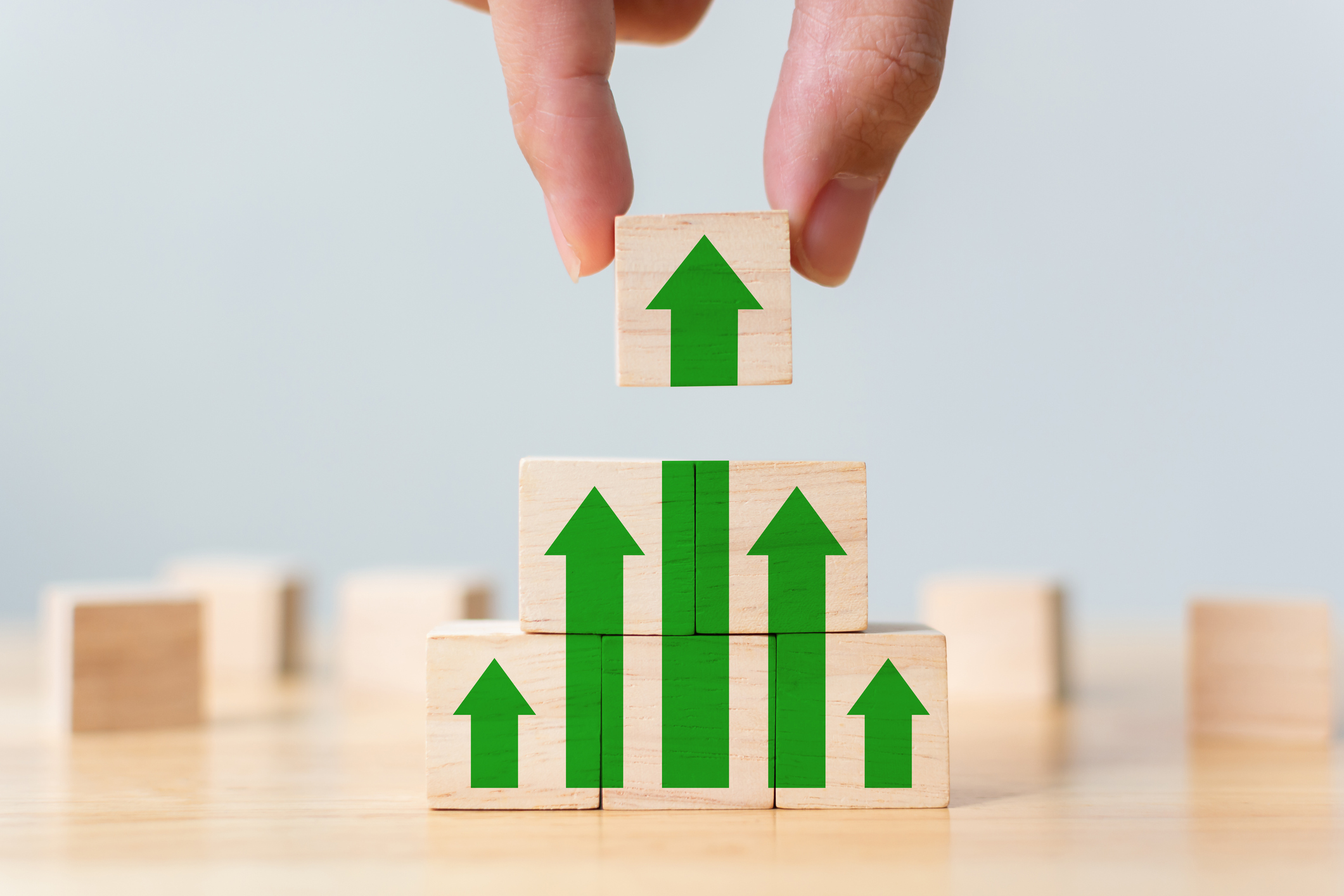 Six blocks in a pyramid showing green arrows pointed upward.