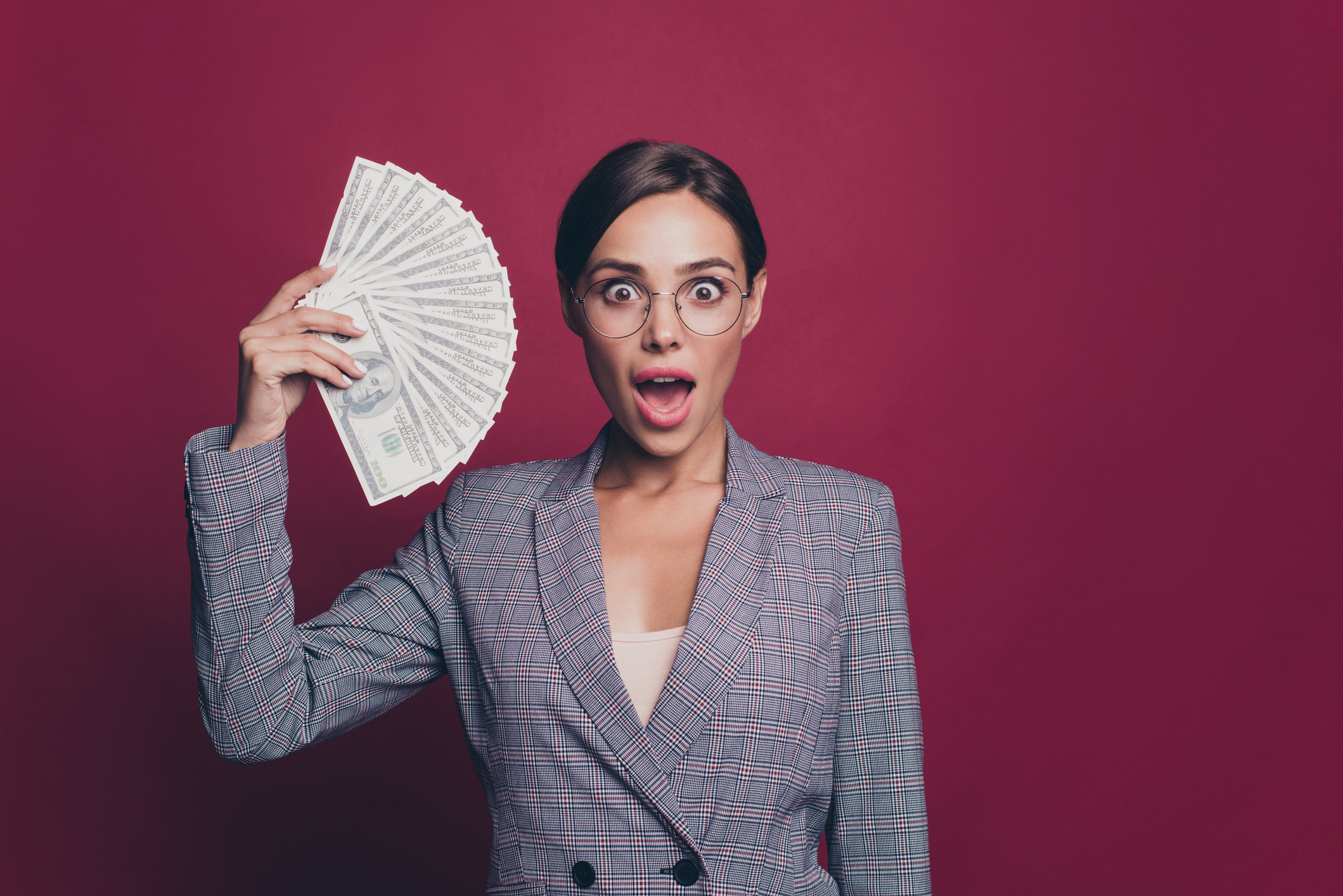 A woman holding up a fan of money.