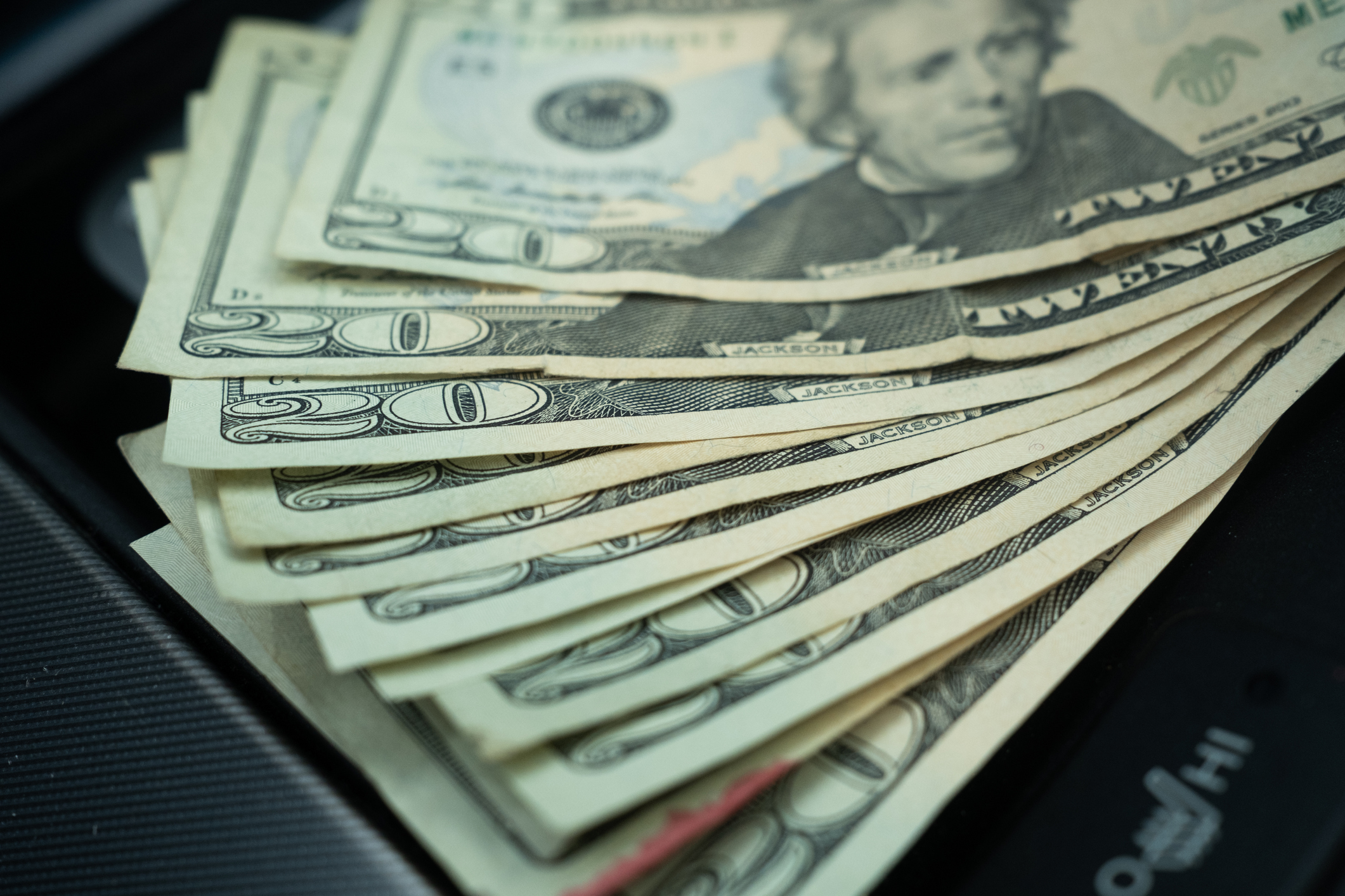 A stack of $20 bills, fanned out on a table