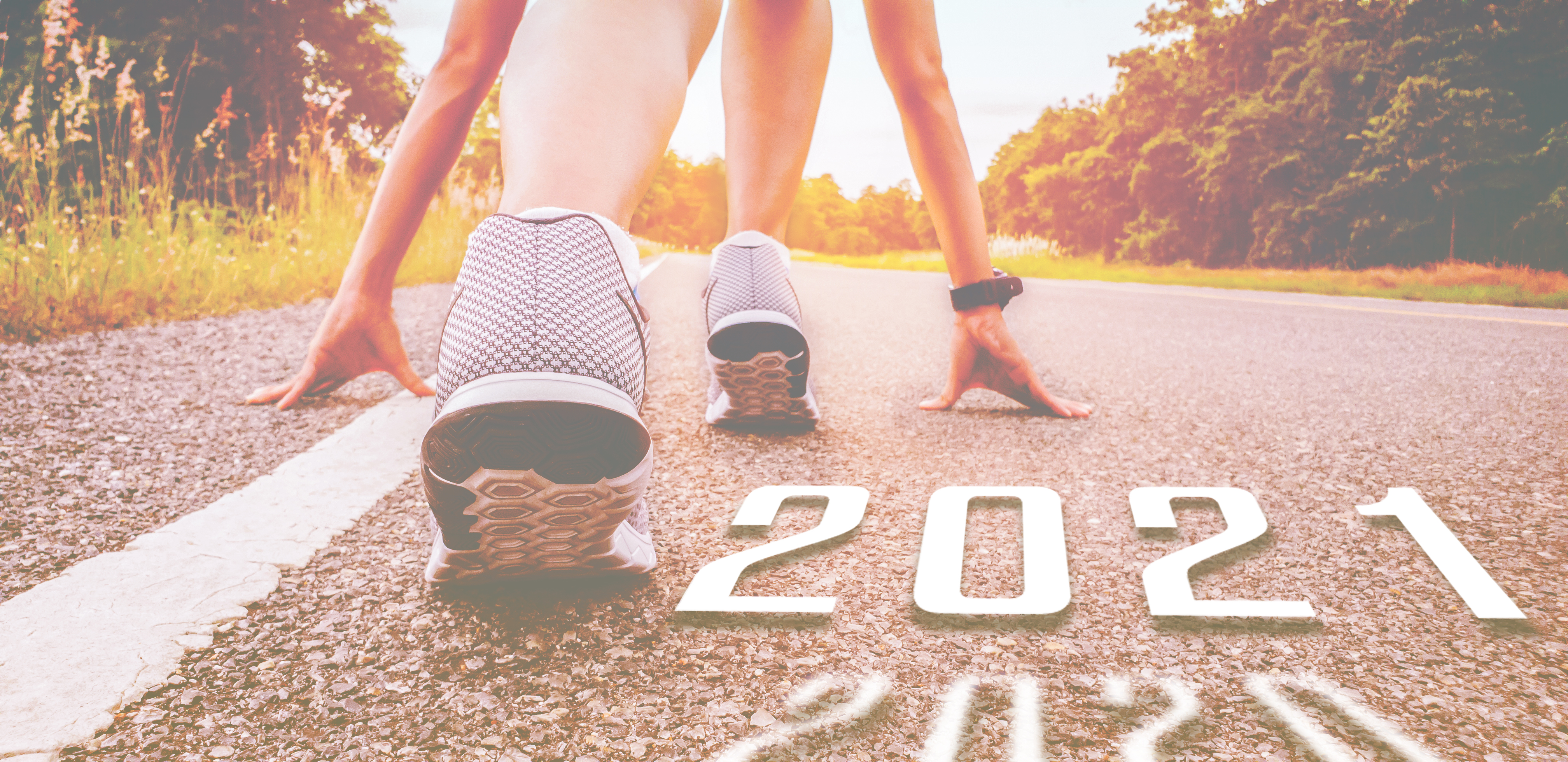 A runner gets ready to run on an open road.