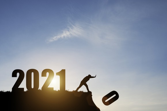 Man pushing 2020 off a cliff