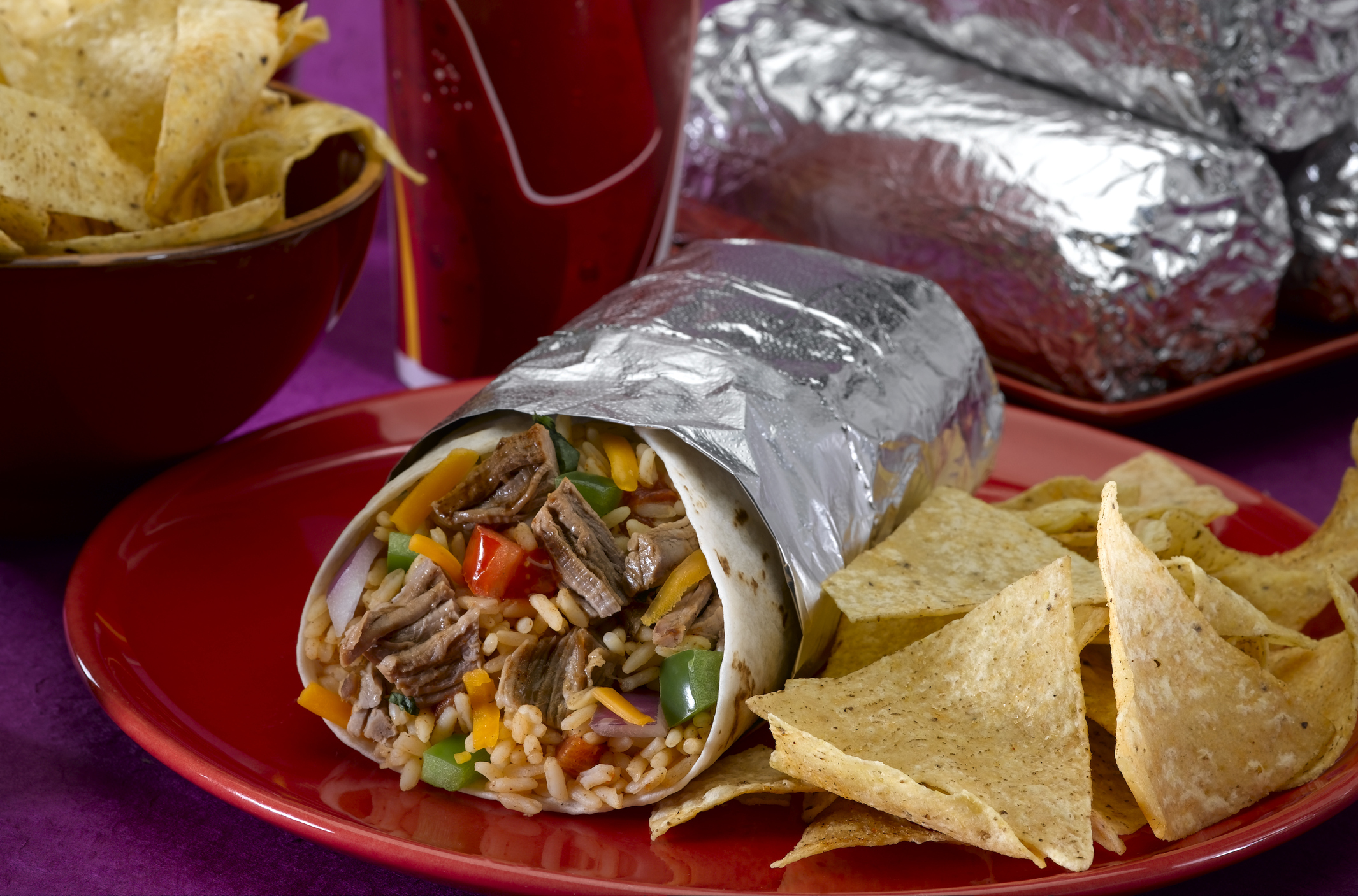 A burrito with a side of chips.