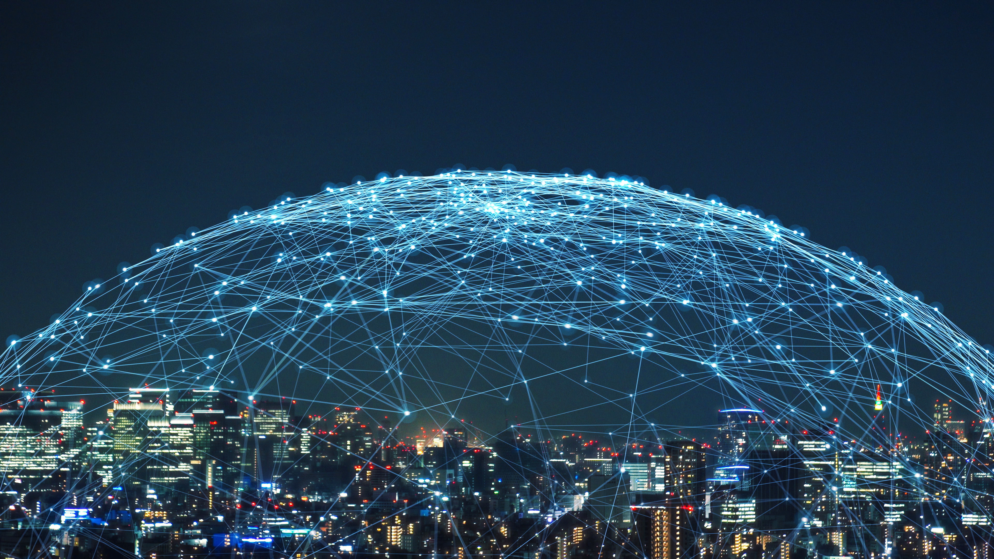 A dome of translucent blue lights sits over a cityscape at night.
