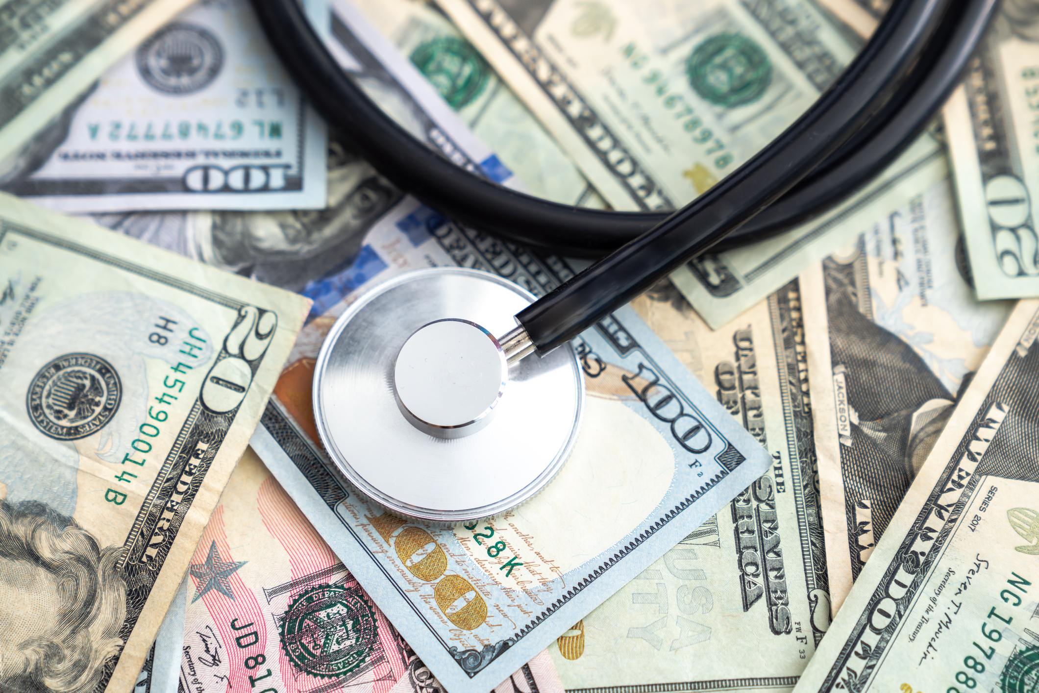 Stethoscope sitting on top of cash