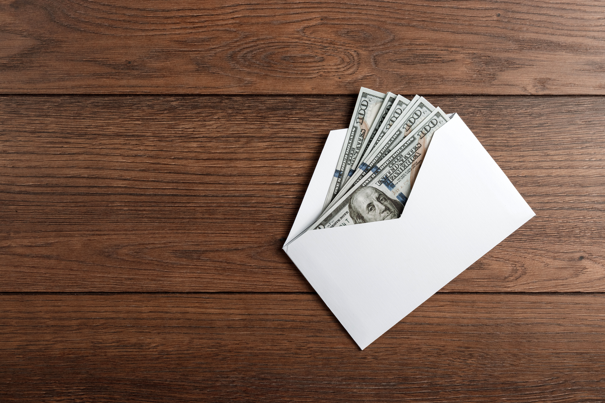 Envelope with hundred dollar bills sticking out of it