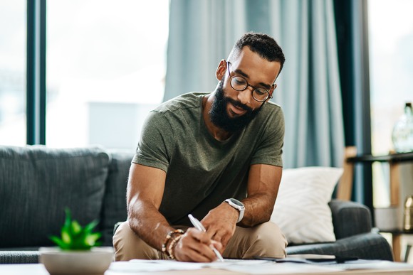 Young man sitting at a table writing