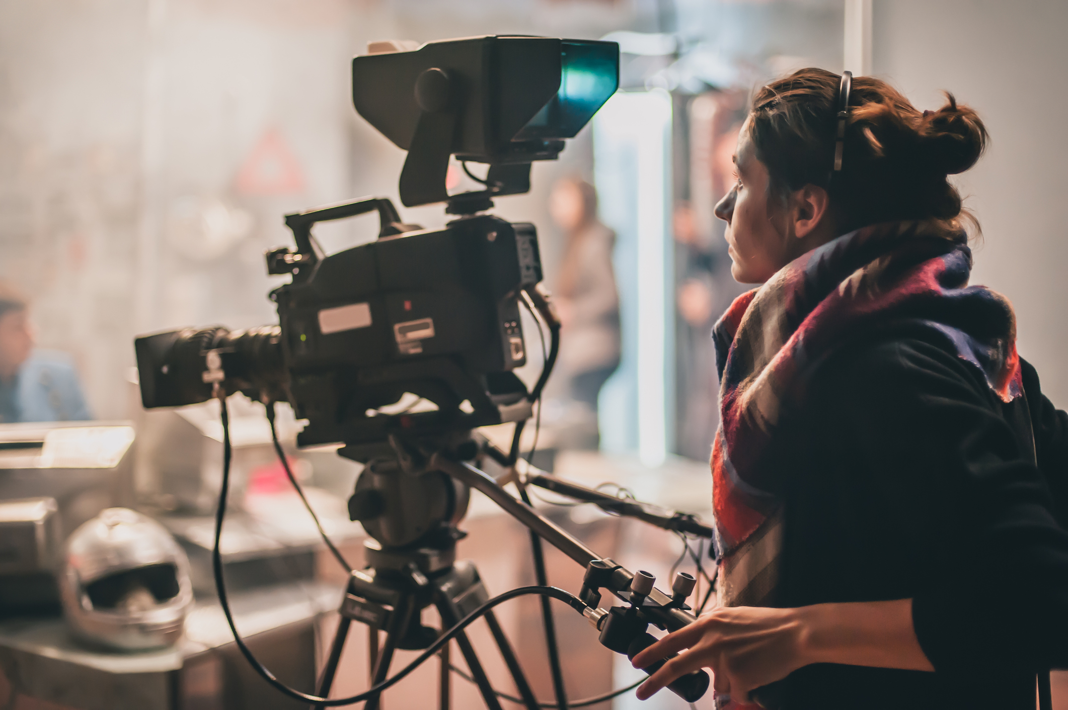 A woman behind a film camera.