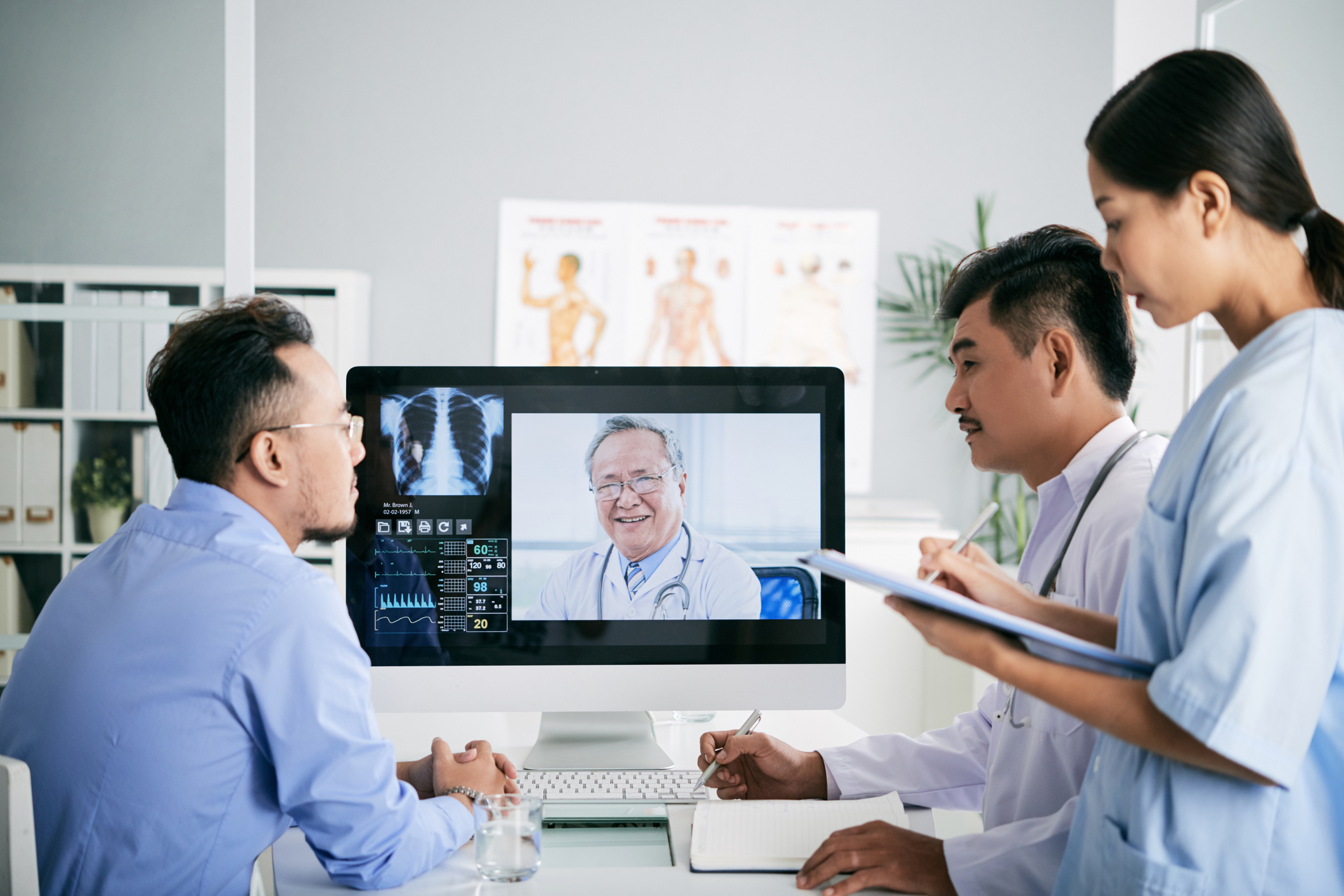 A group of doctors having a virtual consultation with a senior physician.