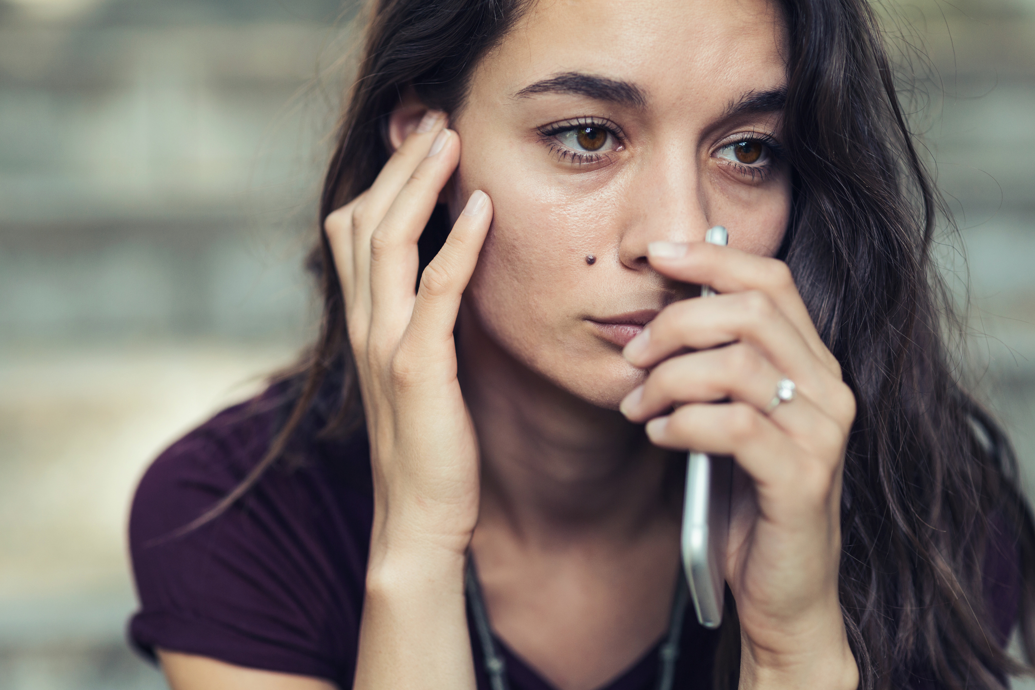 Sad woman holding smartphone