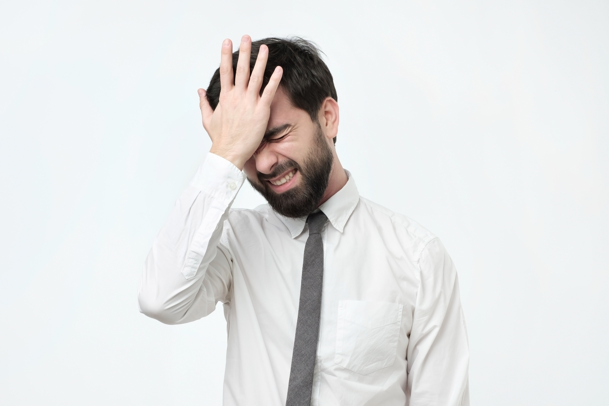 Person in collared shirt and tie smacking their head
