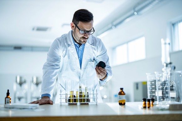 A scientist looks at an instrument in a life sciences lab.