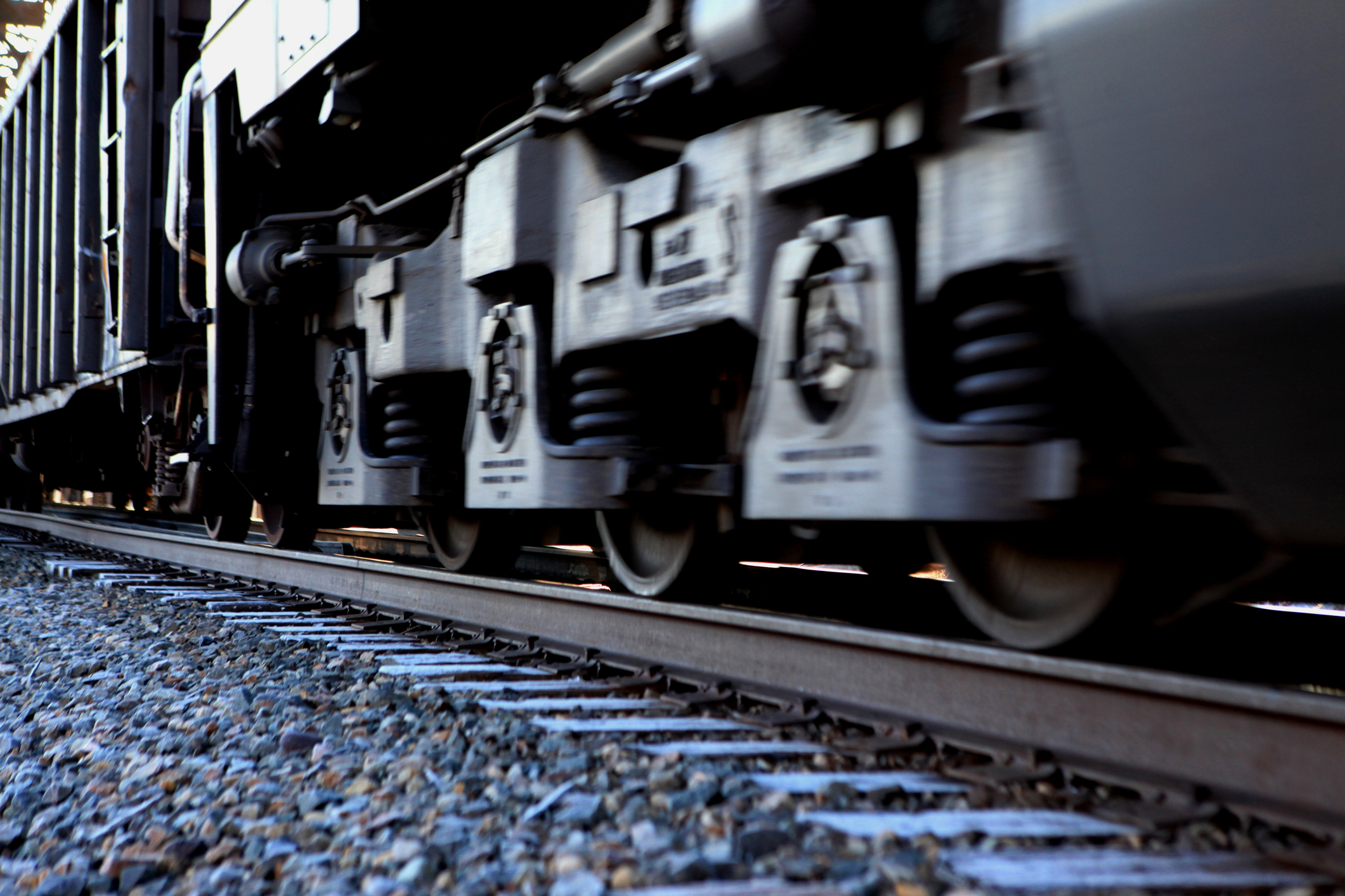 Close-up of freight train wheels moving along a track.