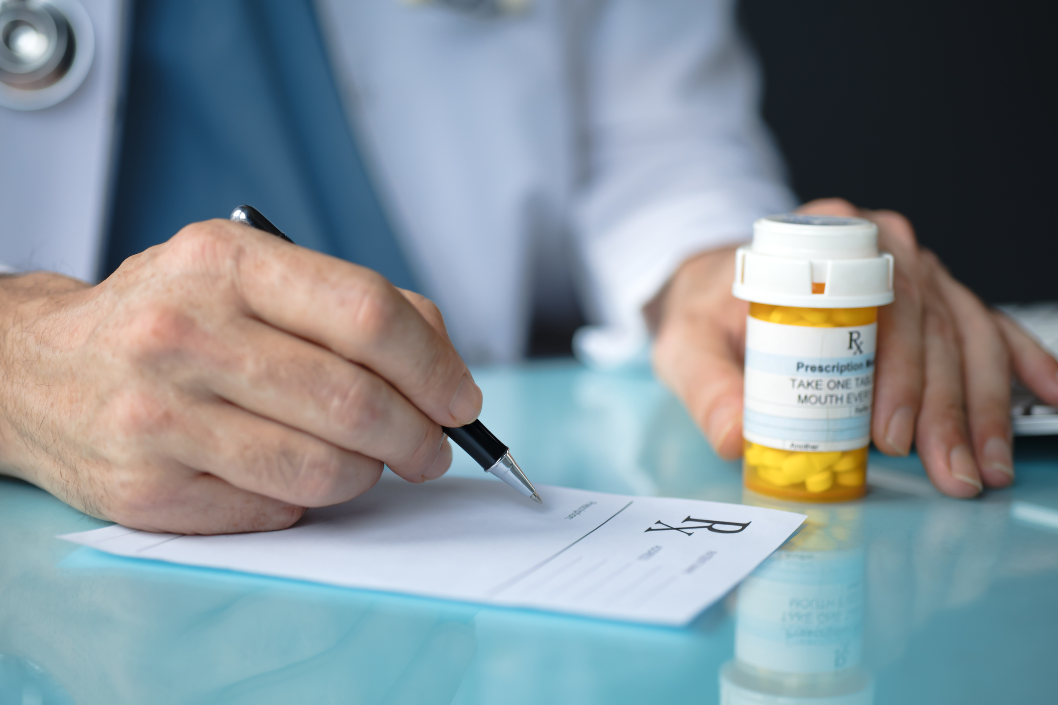 Doctor with pills writing prescription.