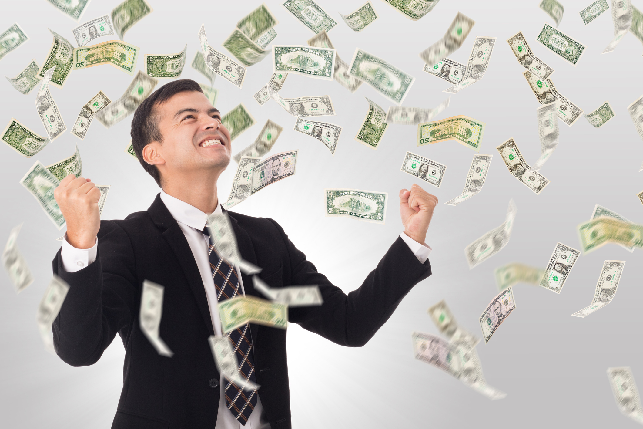 Man pumping hands in victory as money rains down around him.