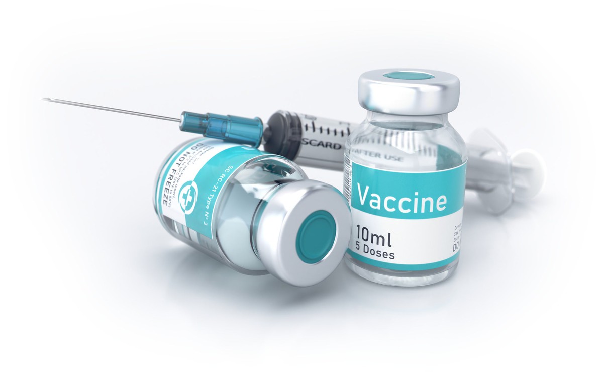 Two vials labeled vaccine next to a syringe.