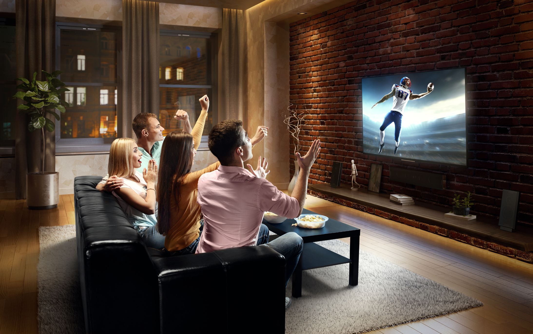 Four friends watching a football game in the living room.
