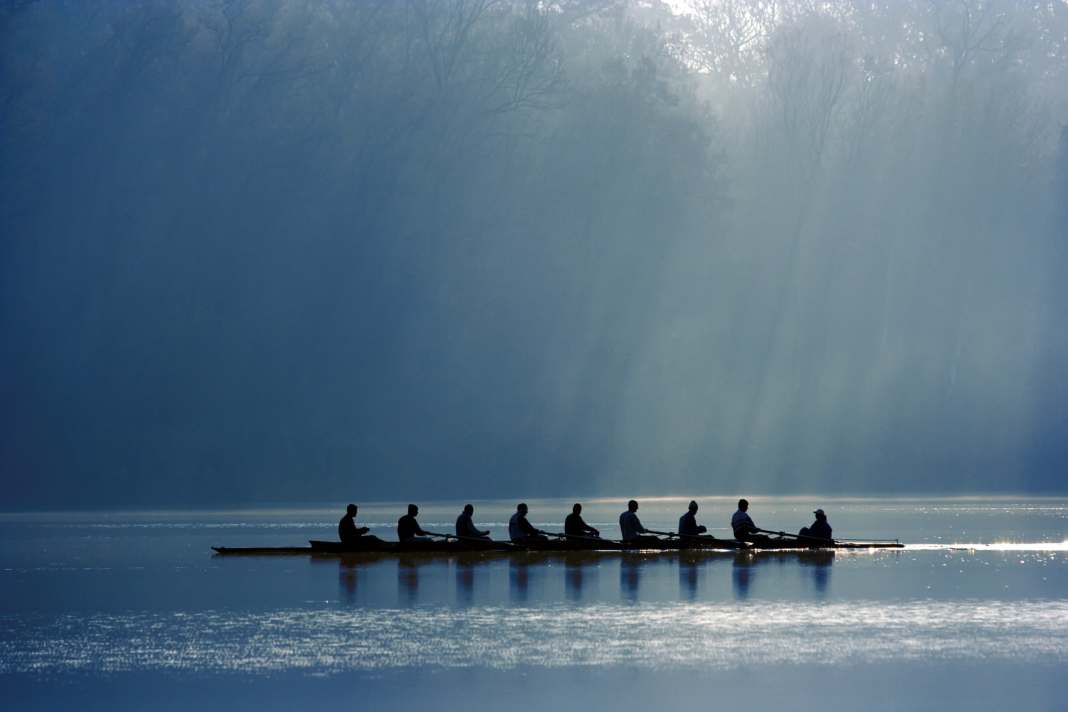 Crew rowing a boat down the river