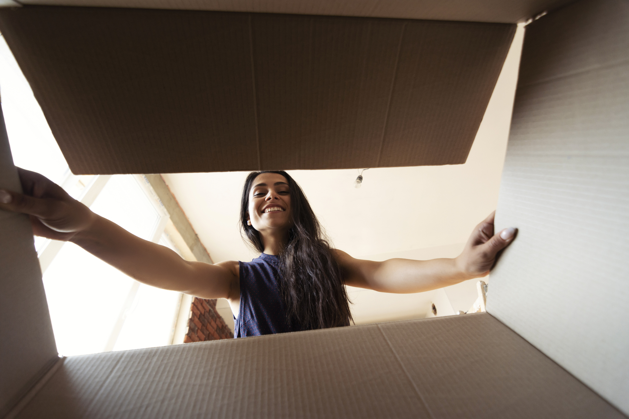 A woman looking into a cardboard box.