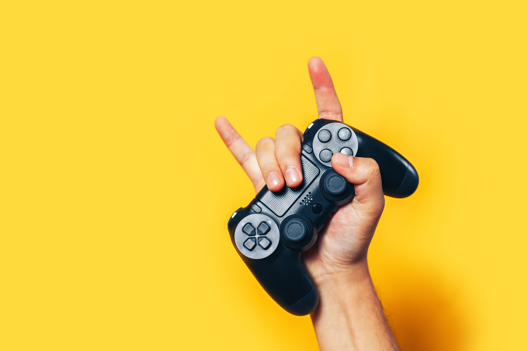 A gamer holds up a PlayStation controller.
