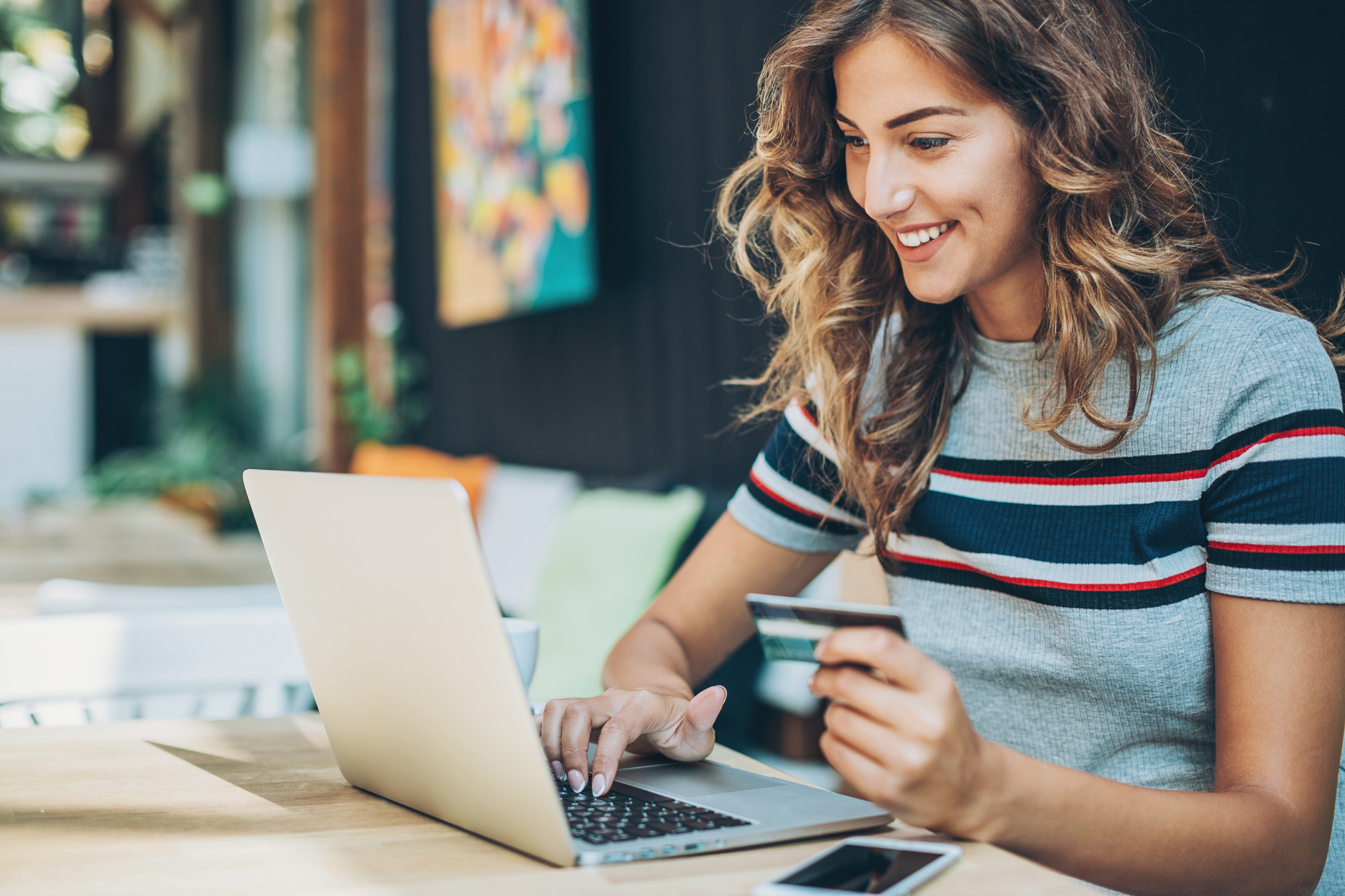 Woman making purchase online using laptop and credit card.