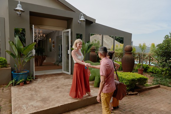 An Airbnb host greets their guest upon arrival.