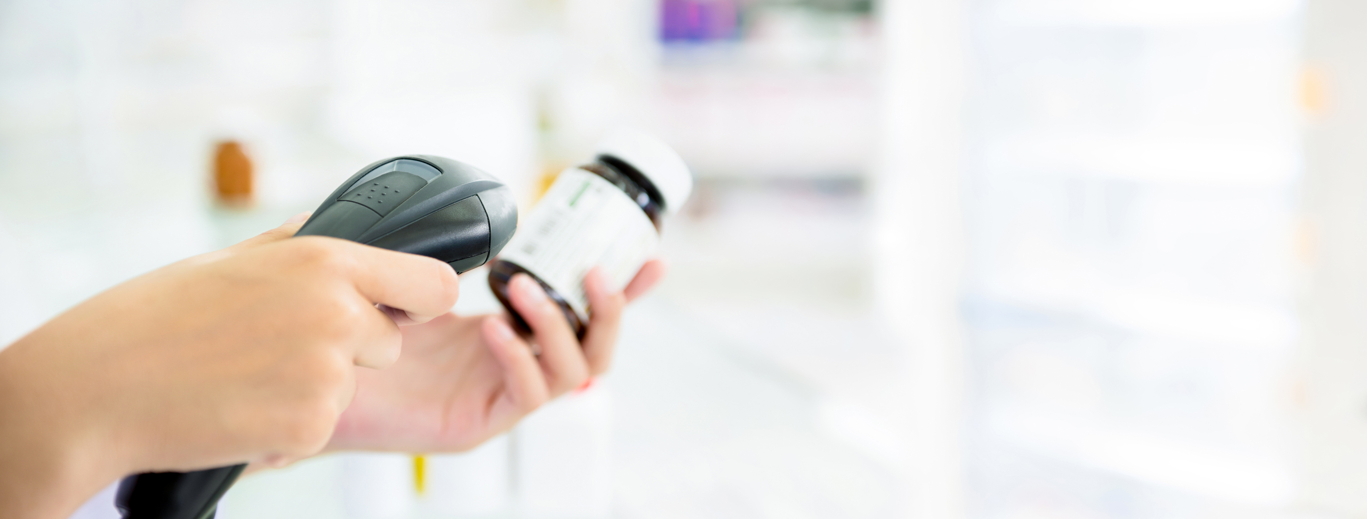 Hand holding a barcode reader scanning a product
