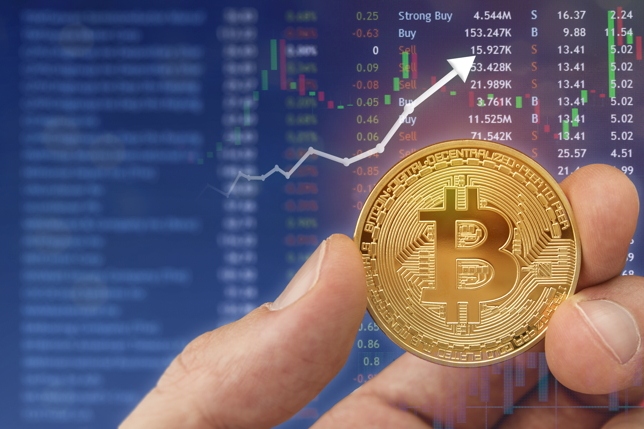 Holding a bitcoin digital currency with laptop in background