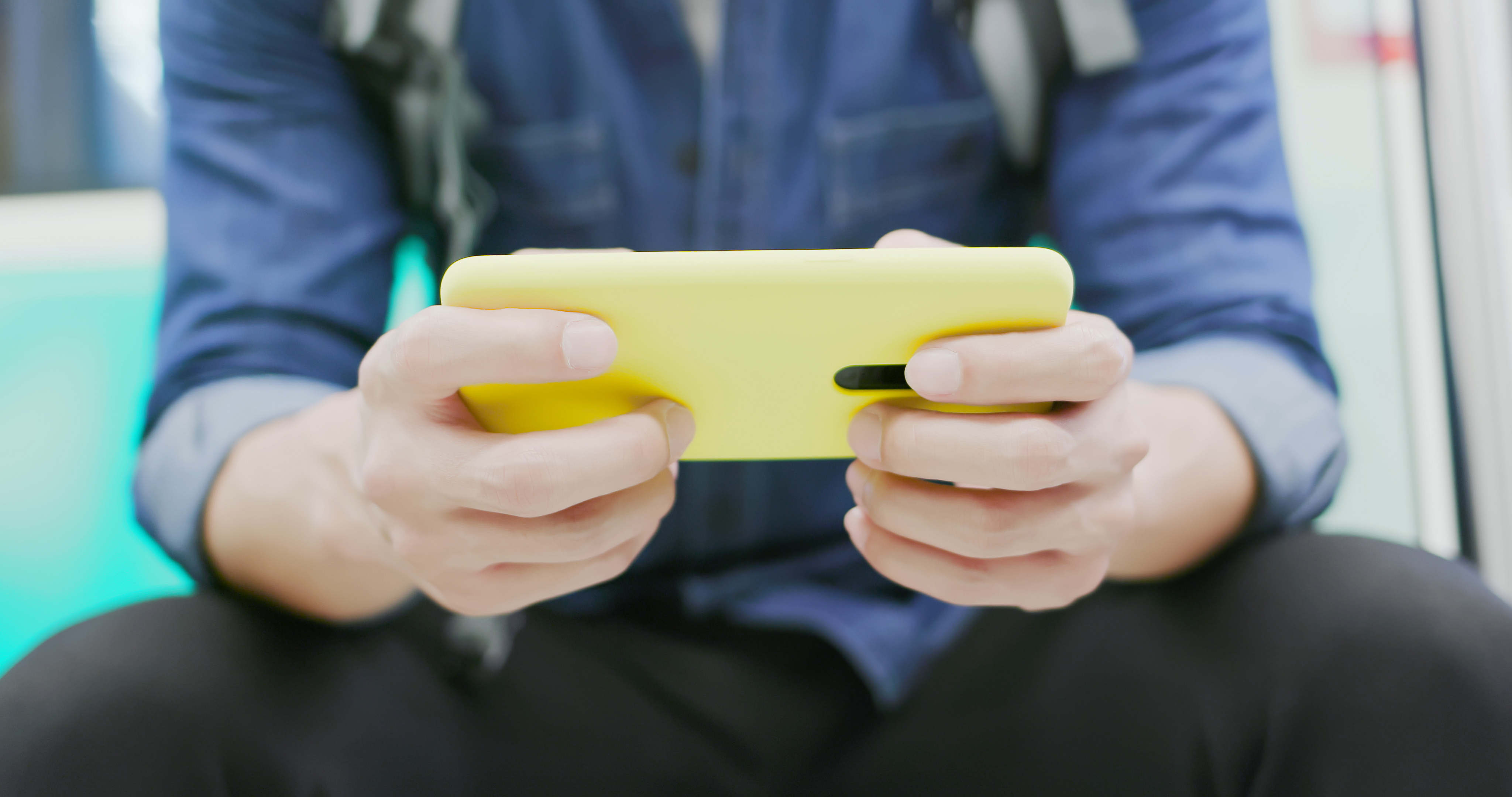 Person holding phone with yellow case.