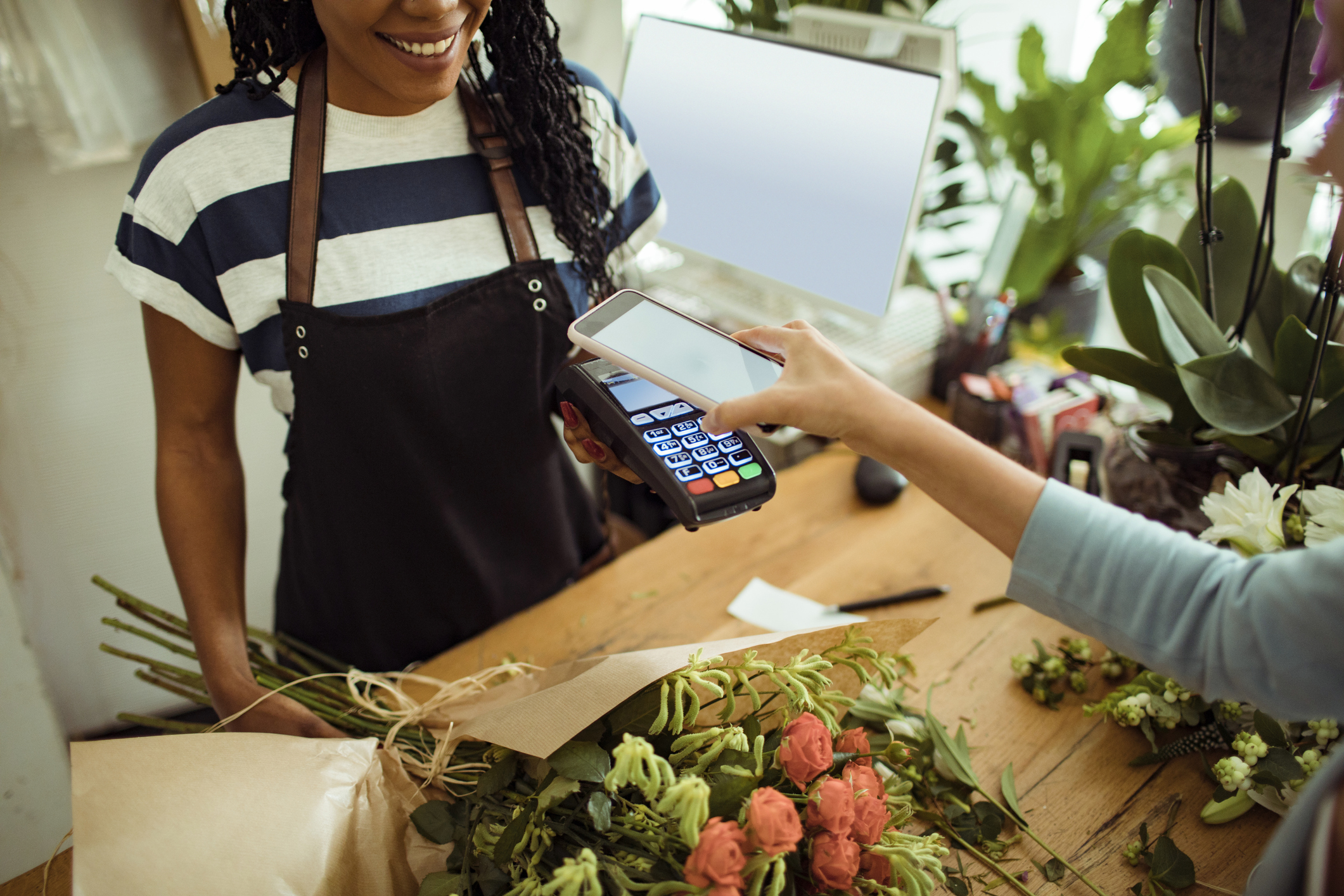 Woman paying for purchase using mobile wallet on phone