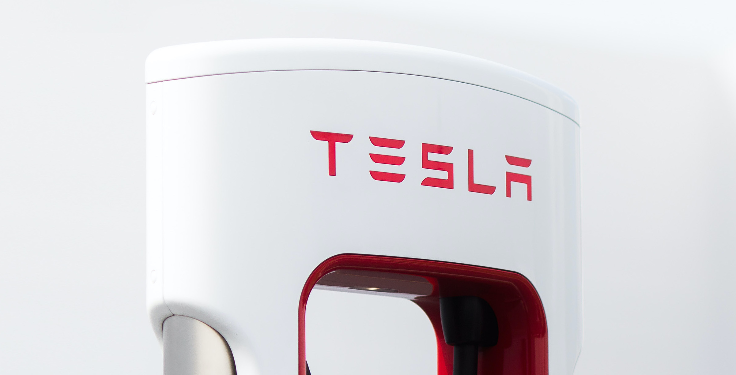 A close-up of the Tesla logo on a Supercharger charging unit.