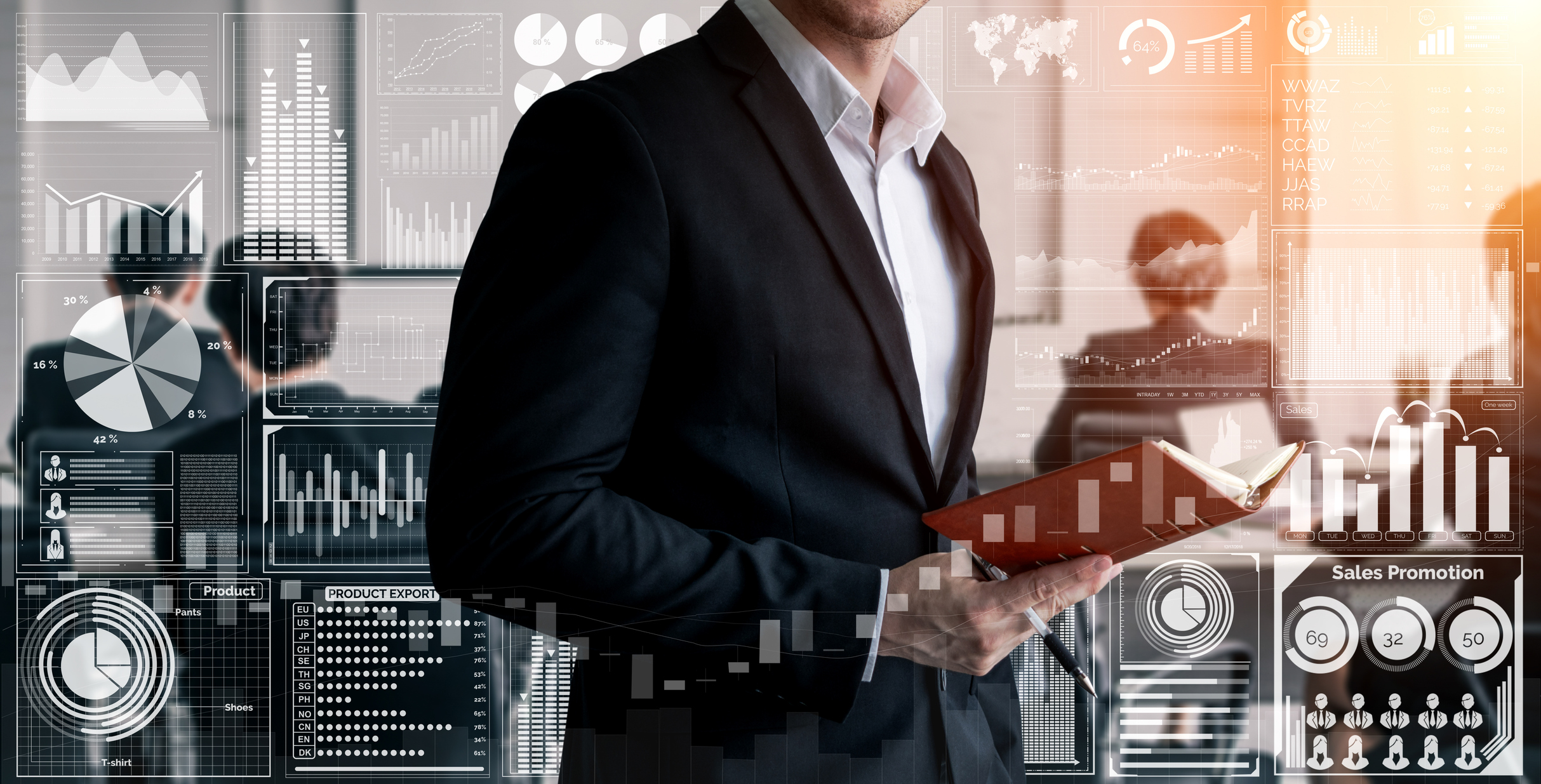 Man in business casual dress seen from neck-down with book open and graphs and charts animations all around him in a conference room.