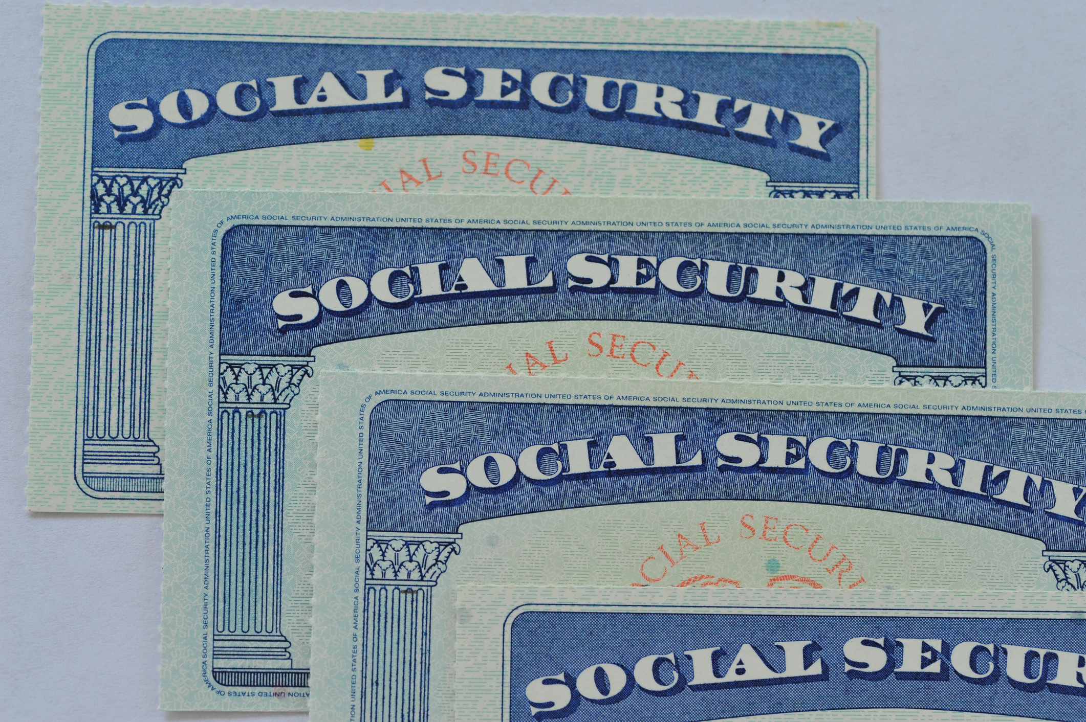 Four Social Security cards resting one on top of another