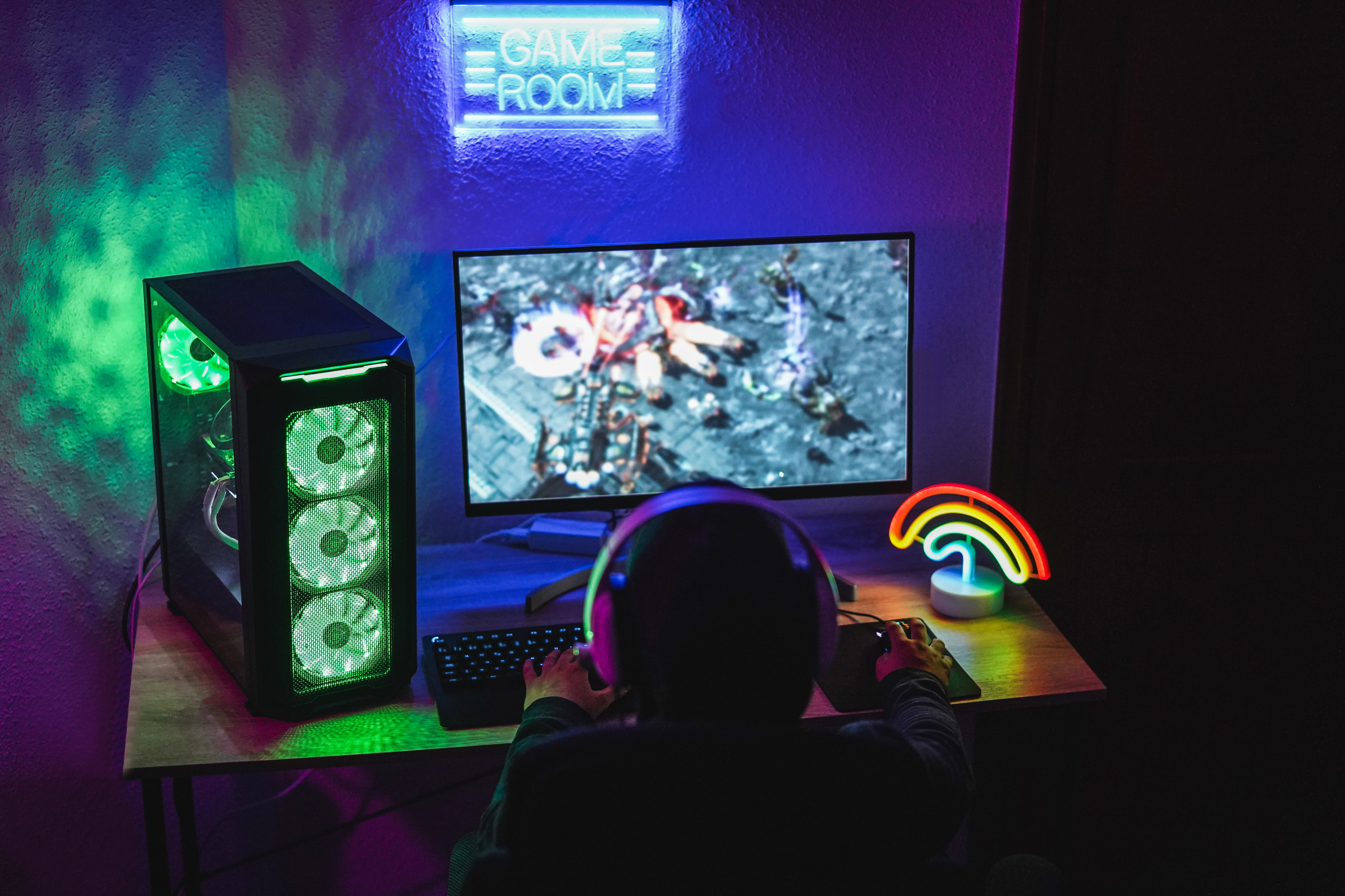 A kid playing a game at a souped-up gaming PC.