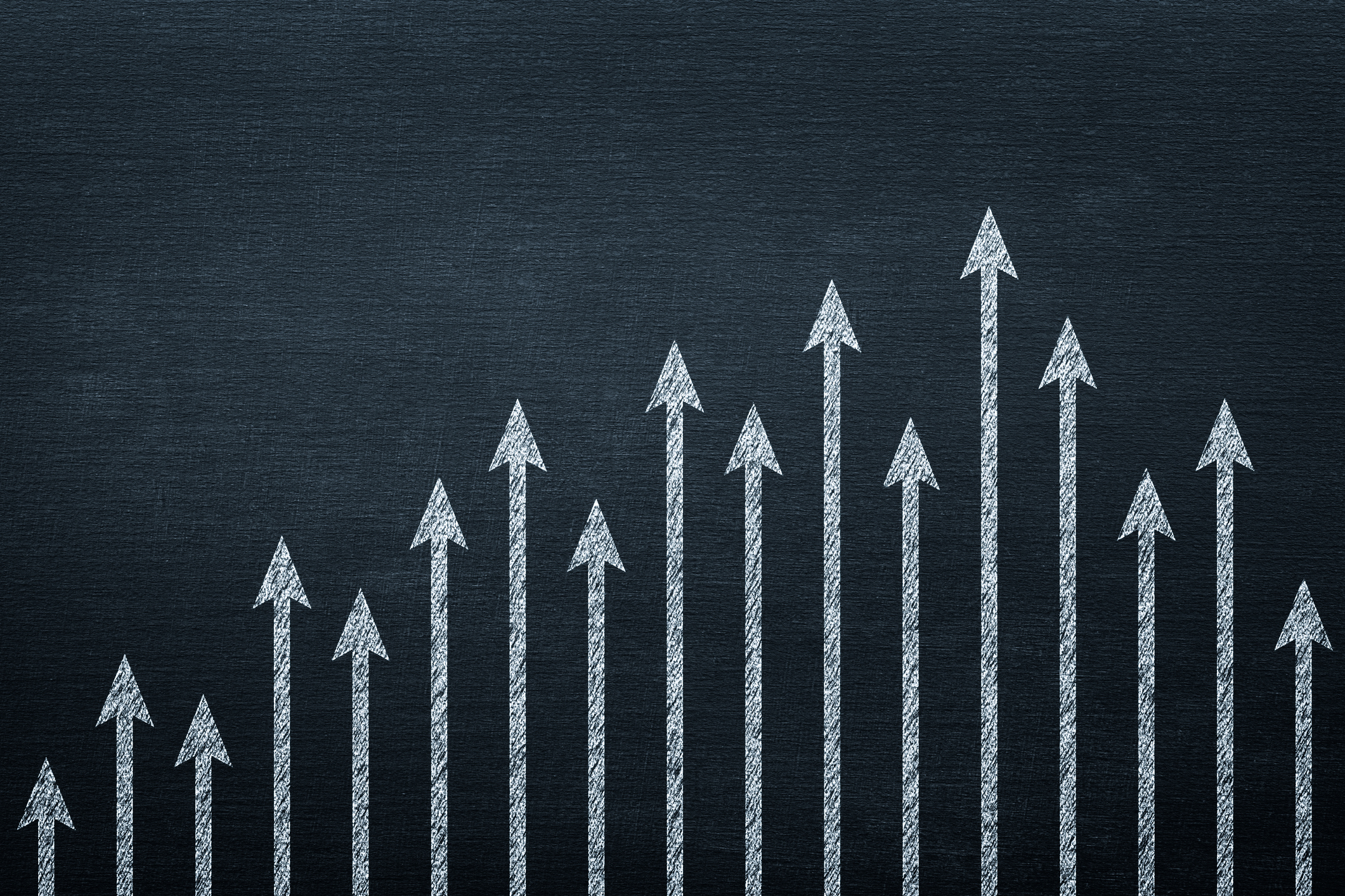 Vertical upward pointing arrows on a blackboard.