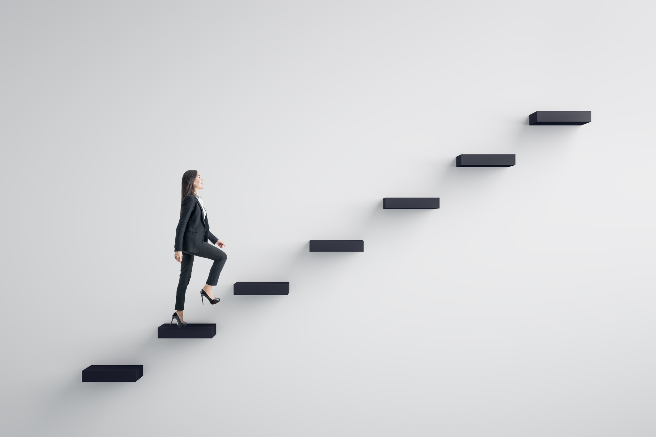 businesswoman climbing up stairs against white background