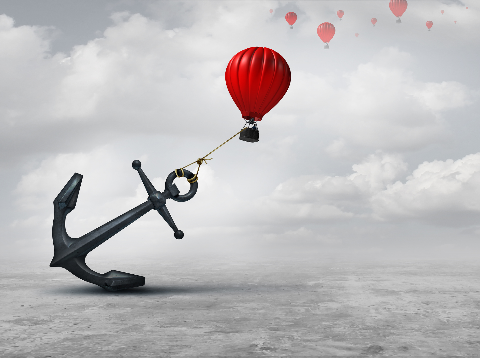 An anchor is attached to a hot air balloon, preventing it from rising with the other hot air balloons.