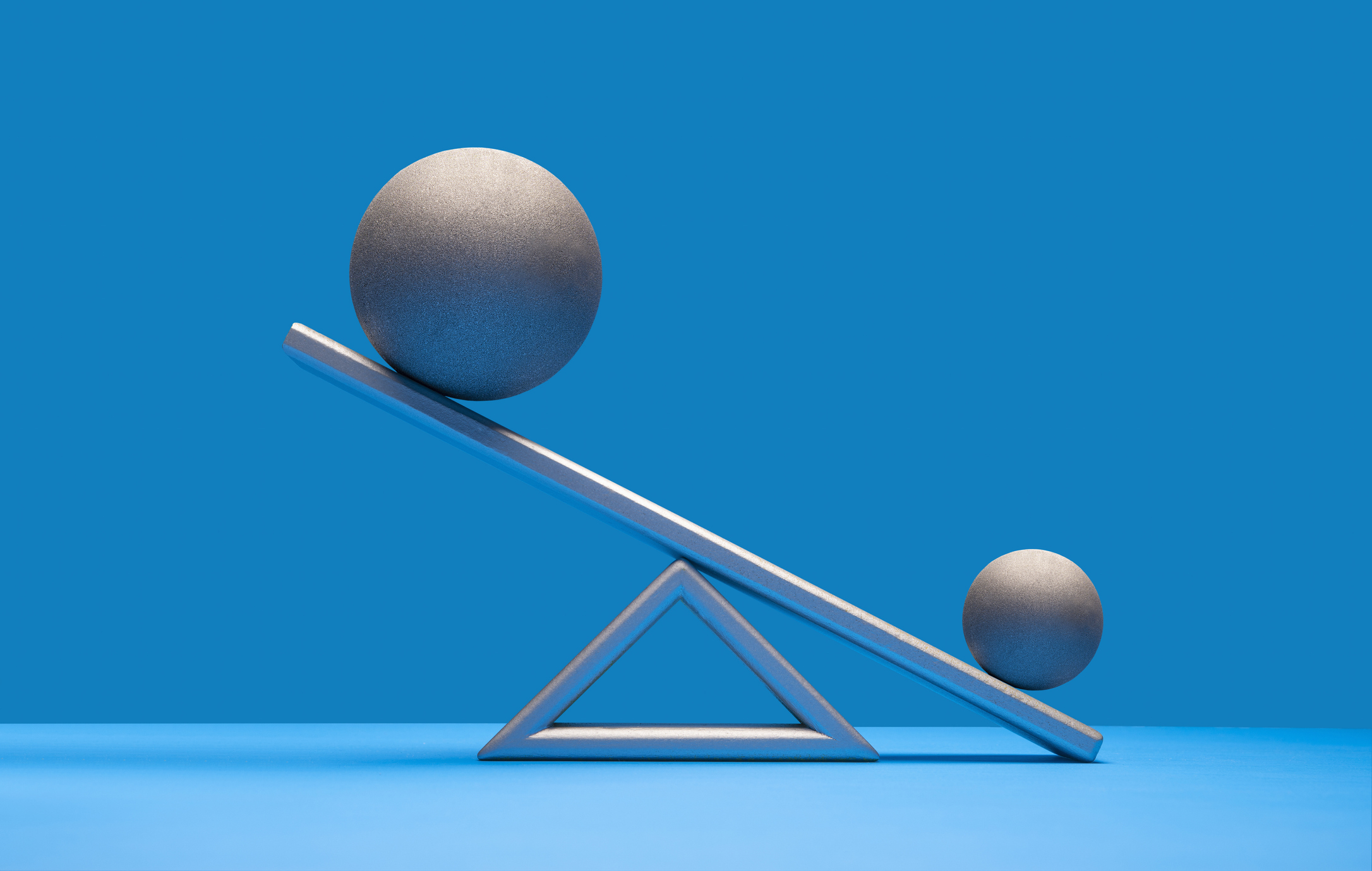 A small ball outweighs a large ball on a teeter-totter