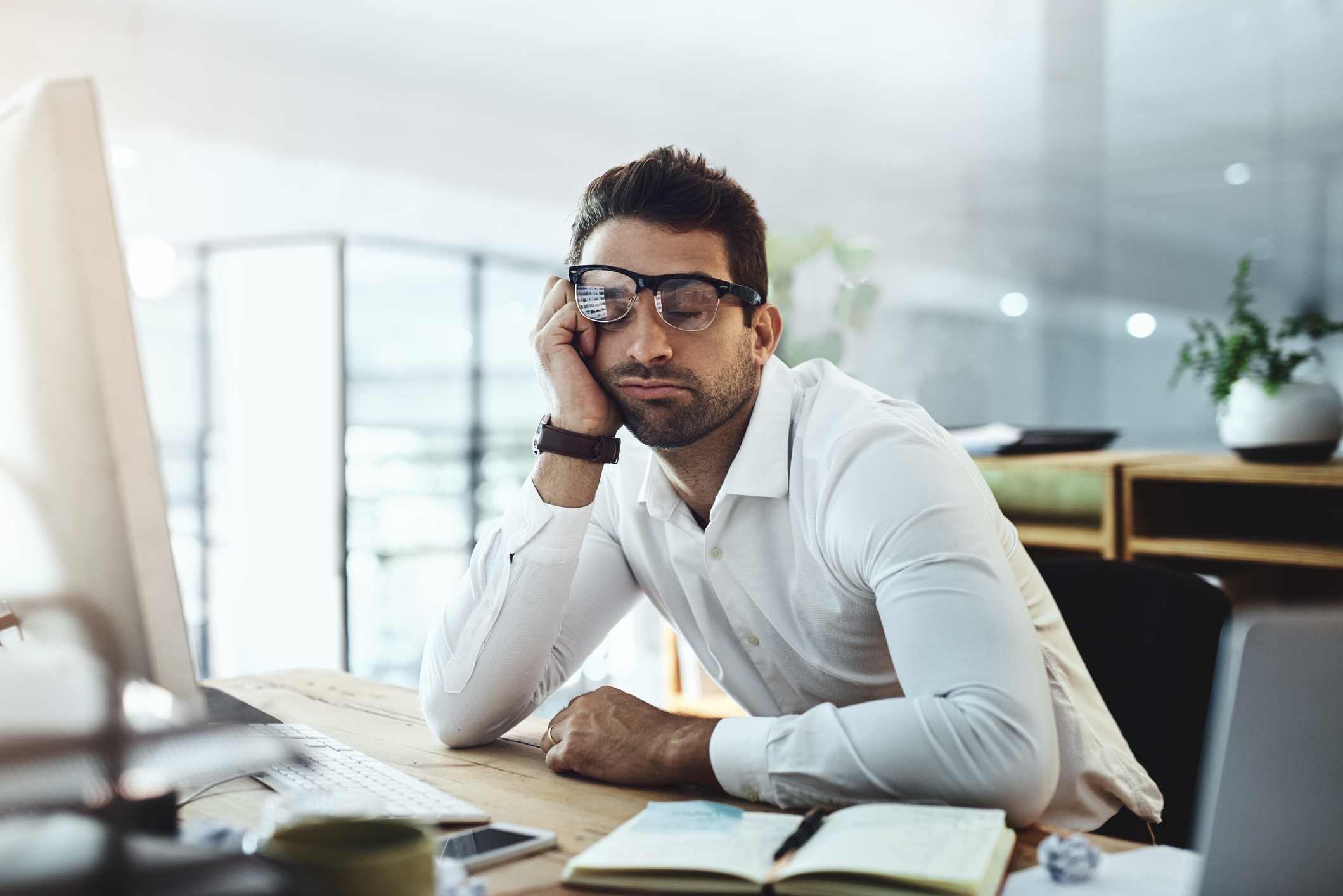 Man at desk with eyes closed