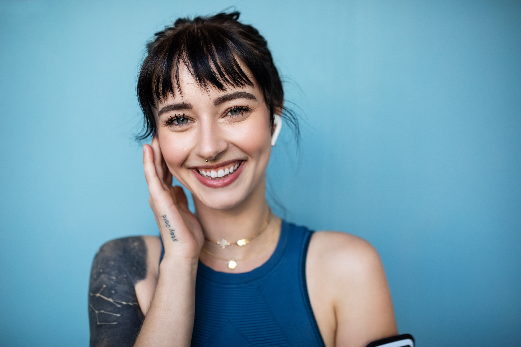 Smiling young woman wearing earbuds