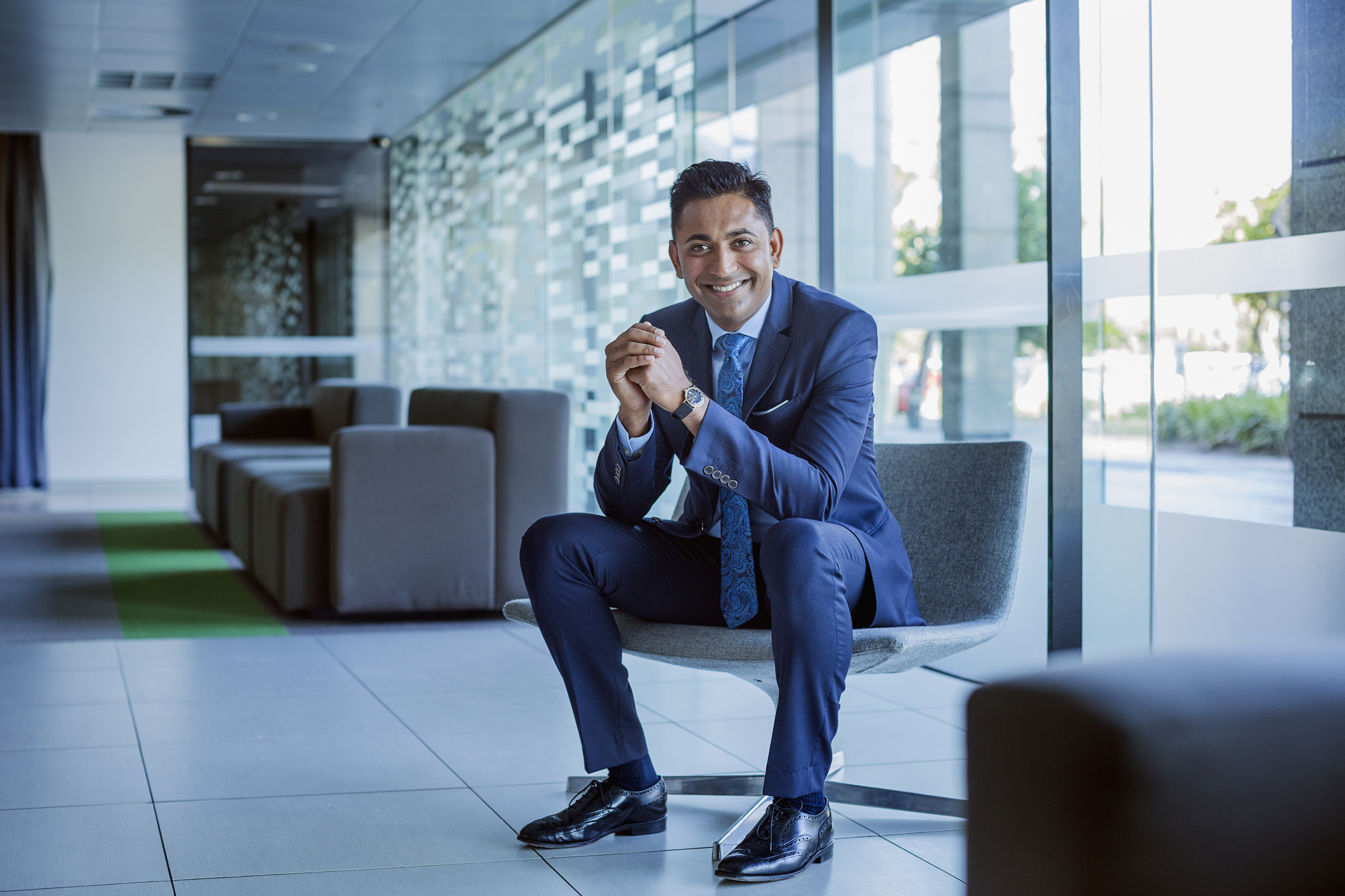 Smiling man in business suit sitting in building lobby