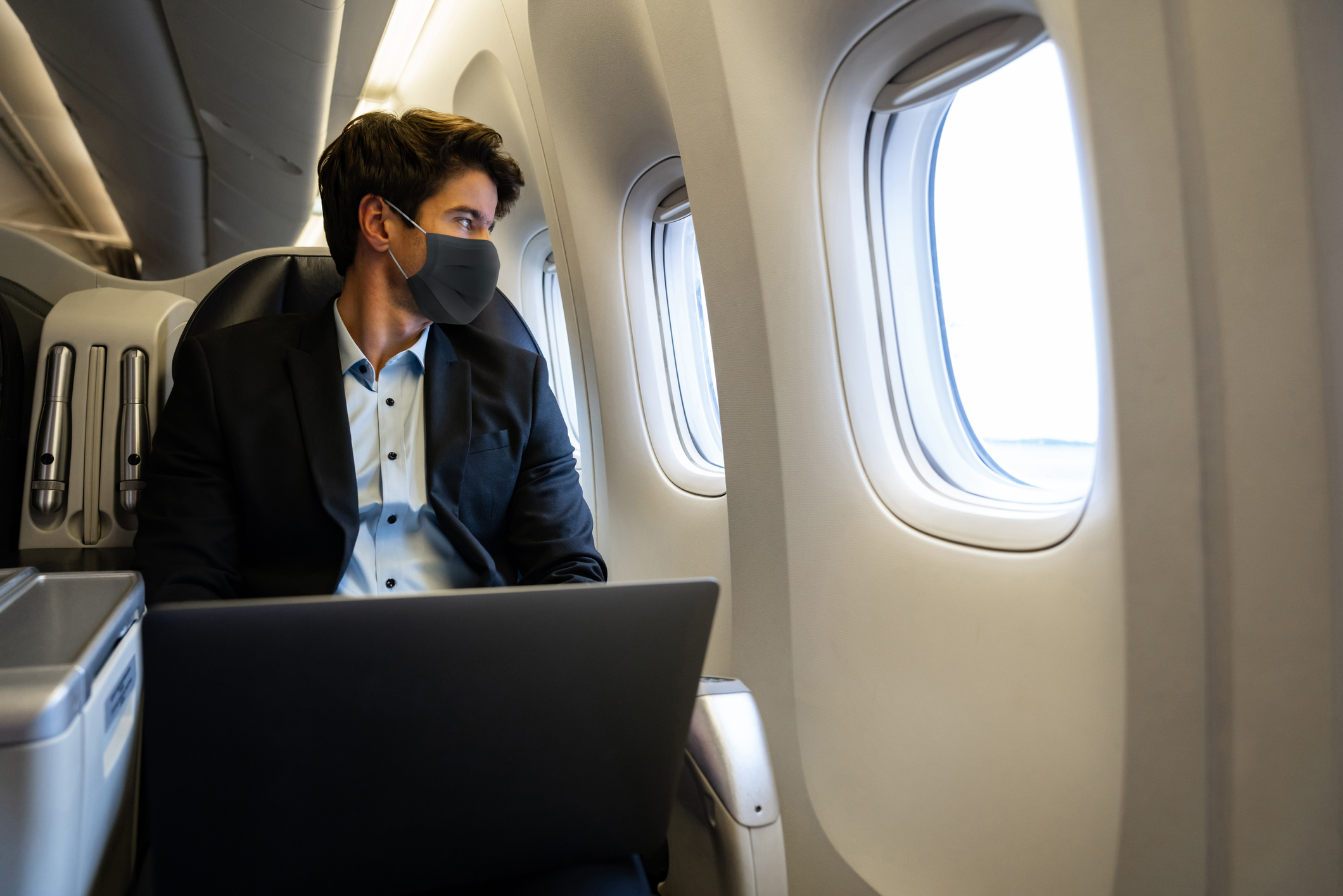 man using laptop on plane