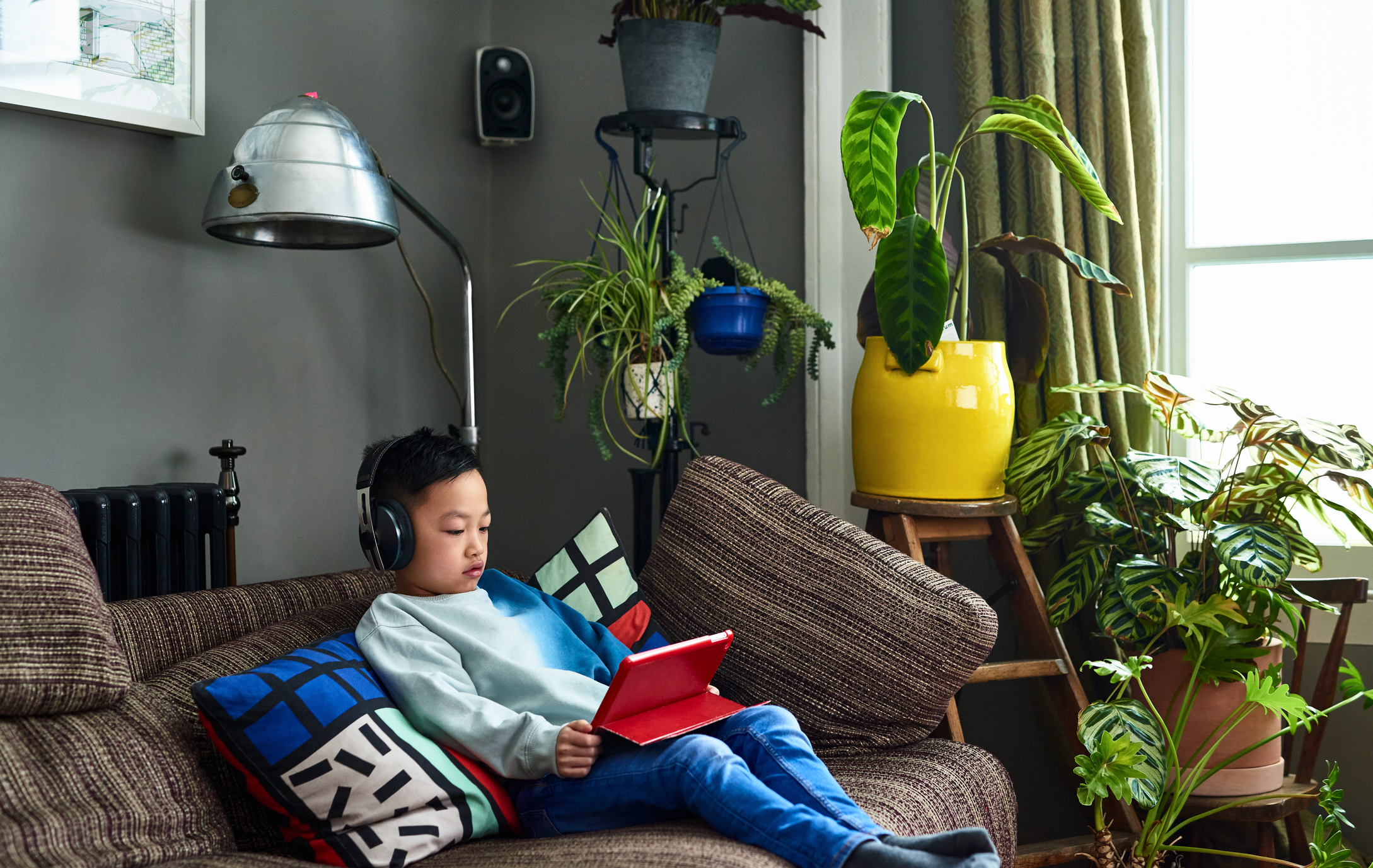 A boy looking at a tablet.