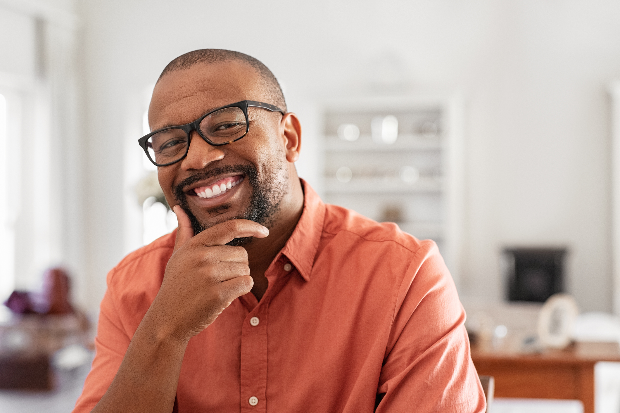 Smiling older man resting hand on chin