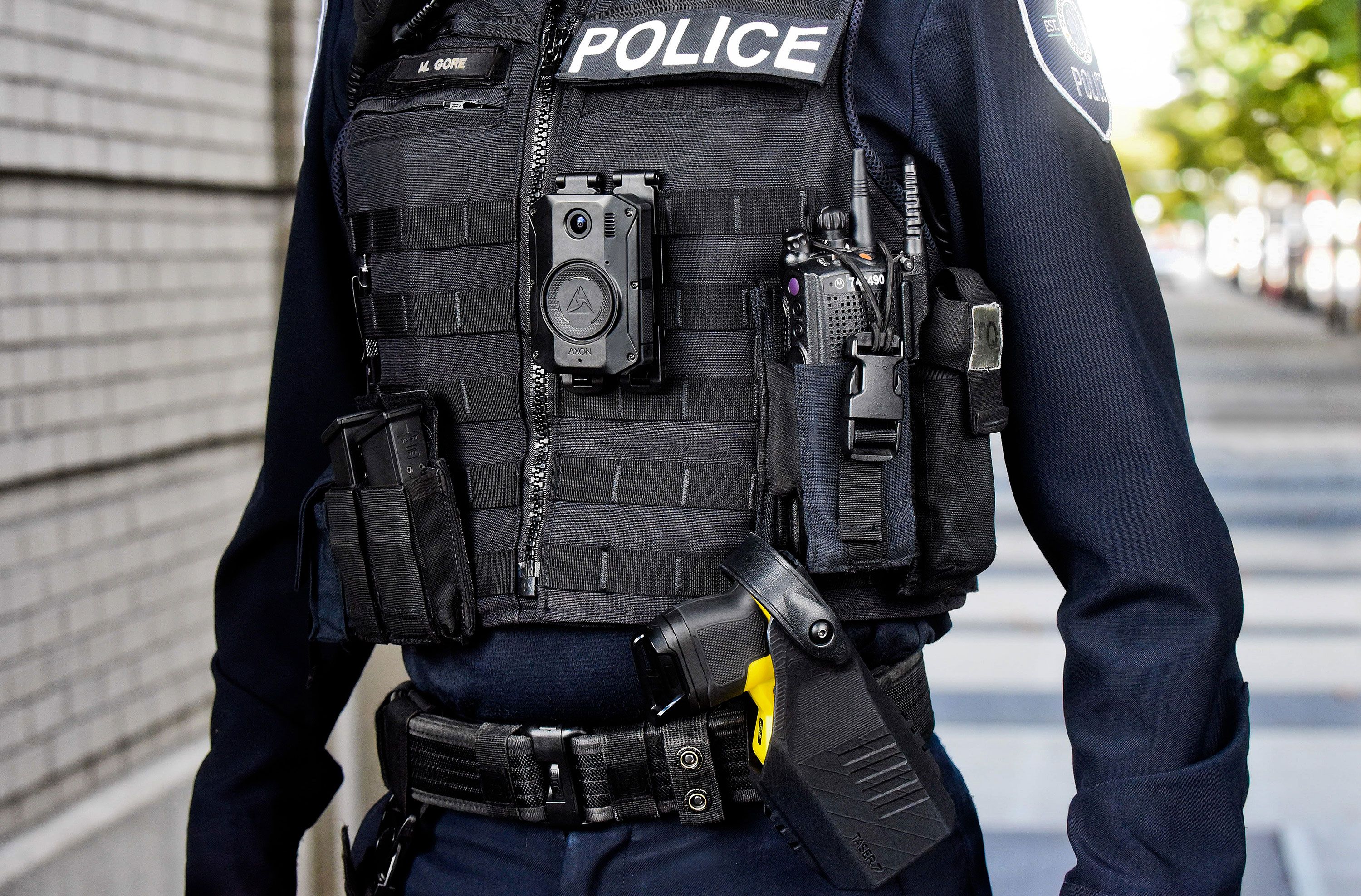 Police officer wearing Axon body camera and TASER device.